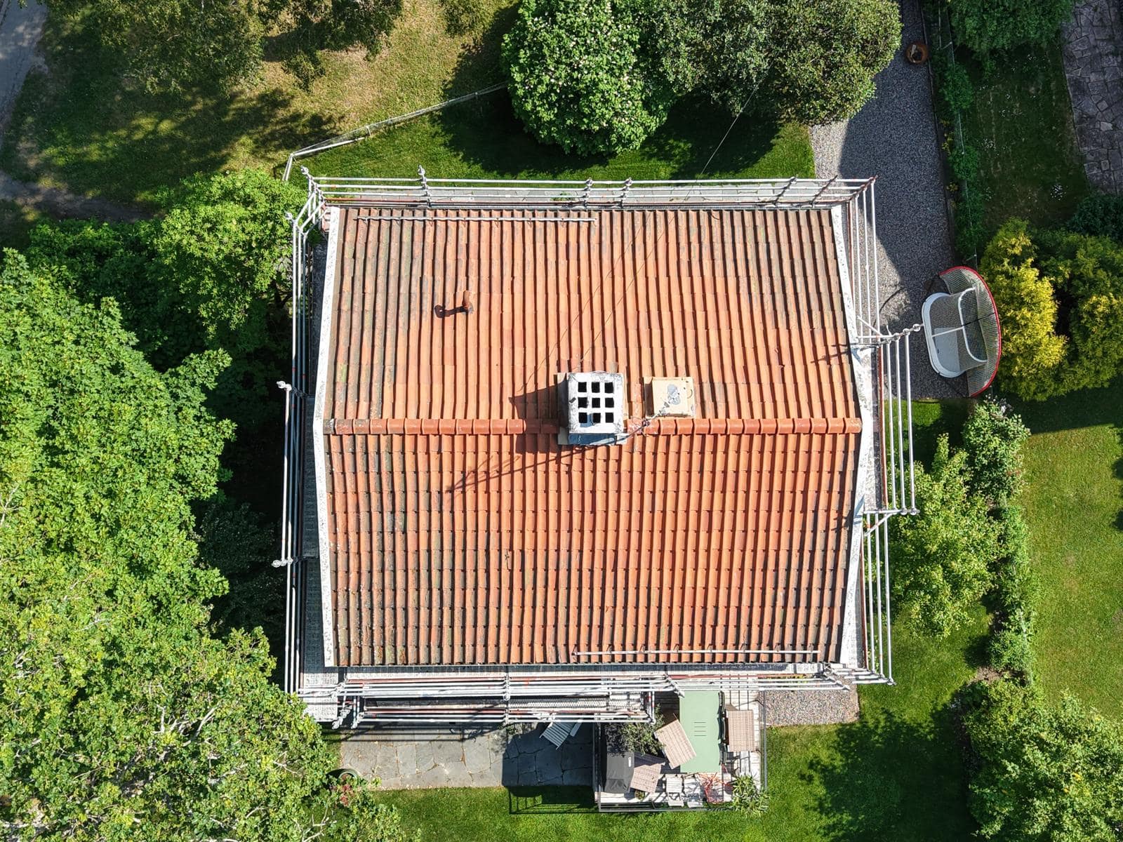 Slitet tegeltak med urblekta och skadade pannor, sett ovanifrån